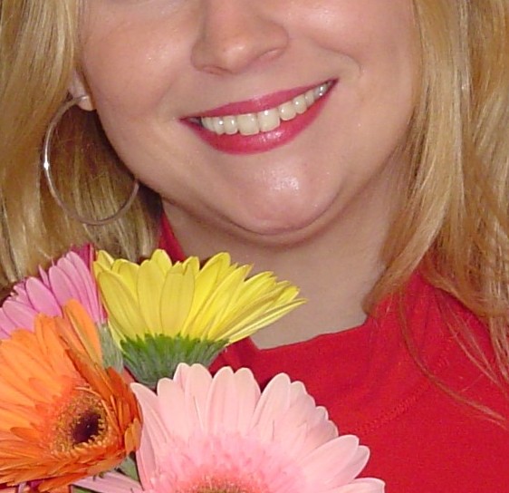 woman smiling while holding flowers