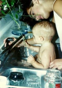 Daughter at age 8 mo. being washed by her big sis, my step daughter, age 15.