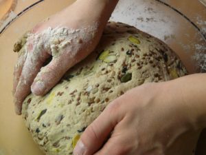 hands shaping a loaf of bread dough