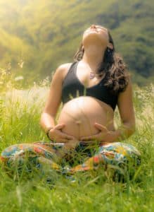 Pregnant woman in a summer field. 