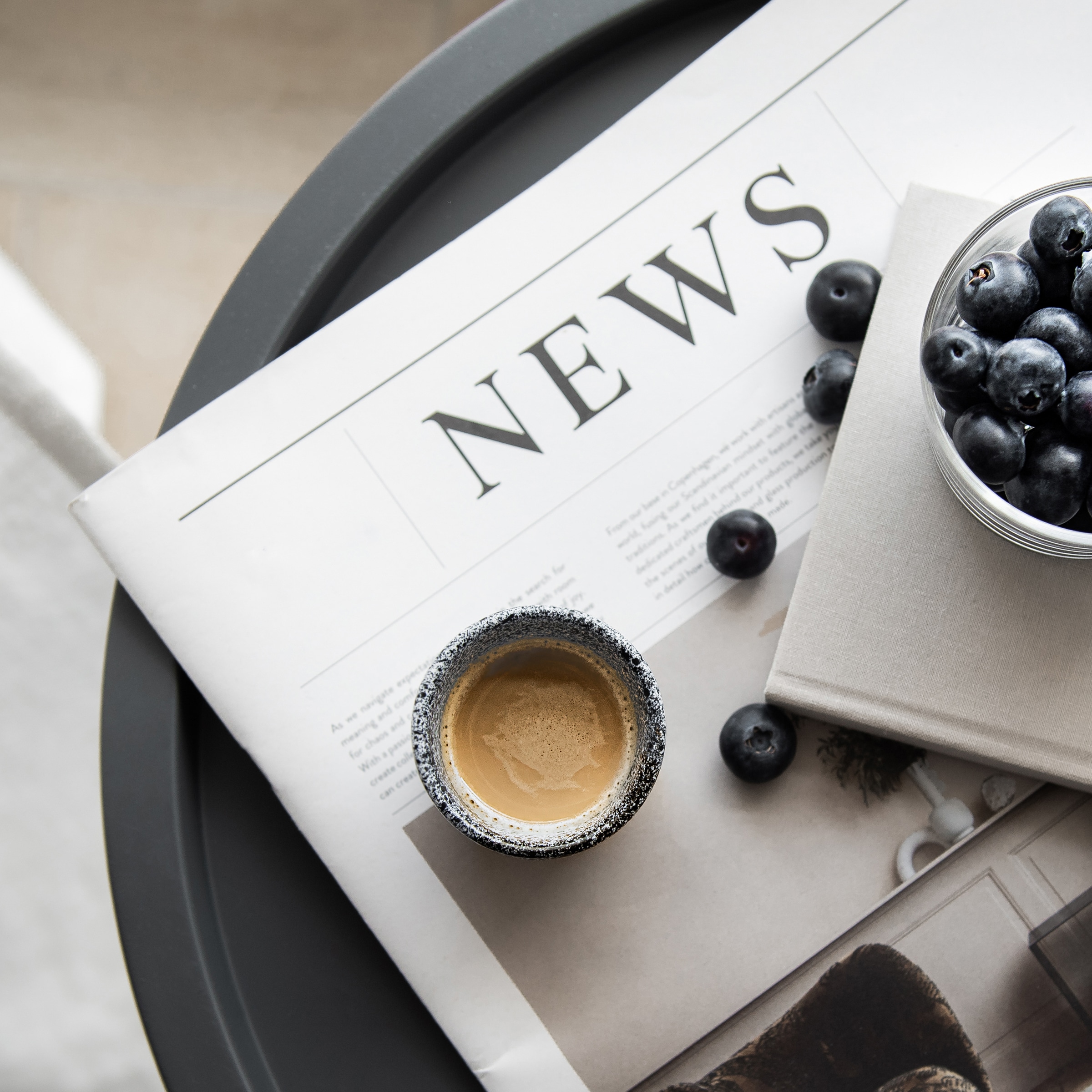 show a newspaper, berries, and cuppa joe